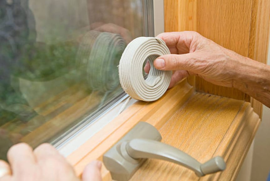 A person holding a roll of weatherstrip for windows