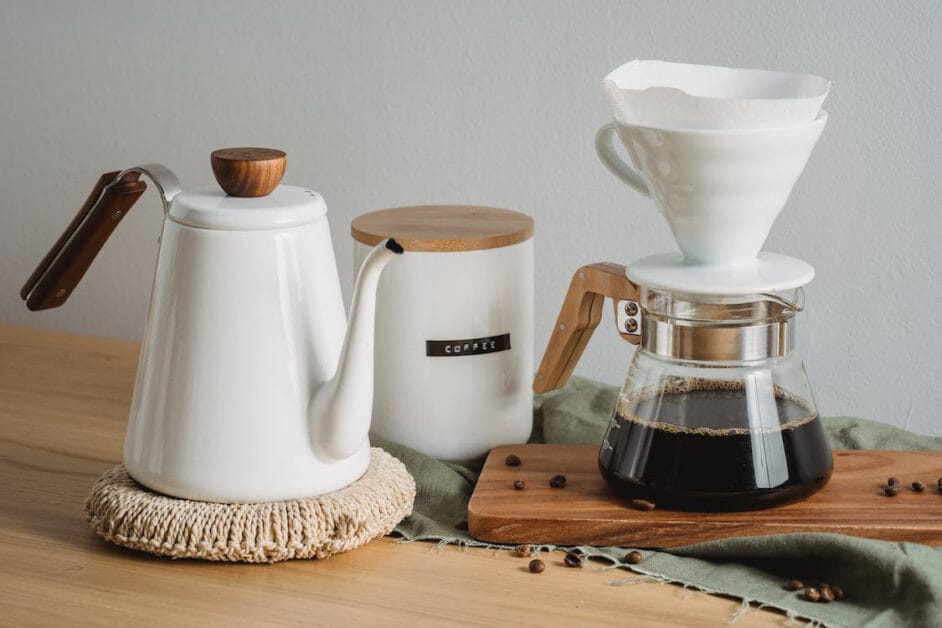 A clean white coffee maker and a bag of coffee beans on a wooden table