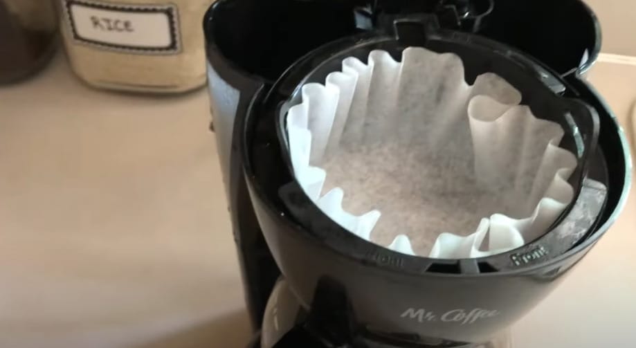 A clean coffee maker with a filter sitting on top of it