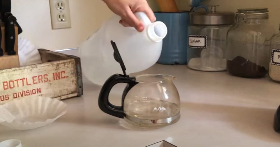 A person pouring a solution into a coffee jar