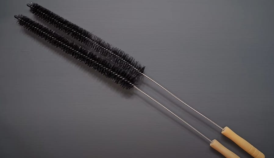 A pair of small black brushes to clean refrigerator coils