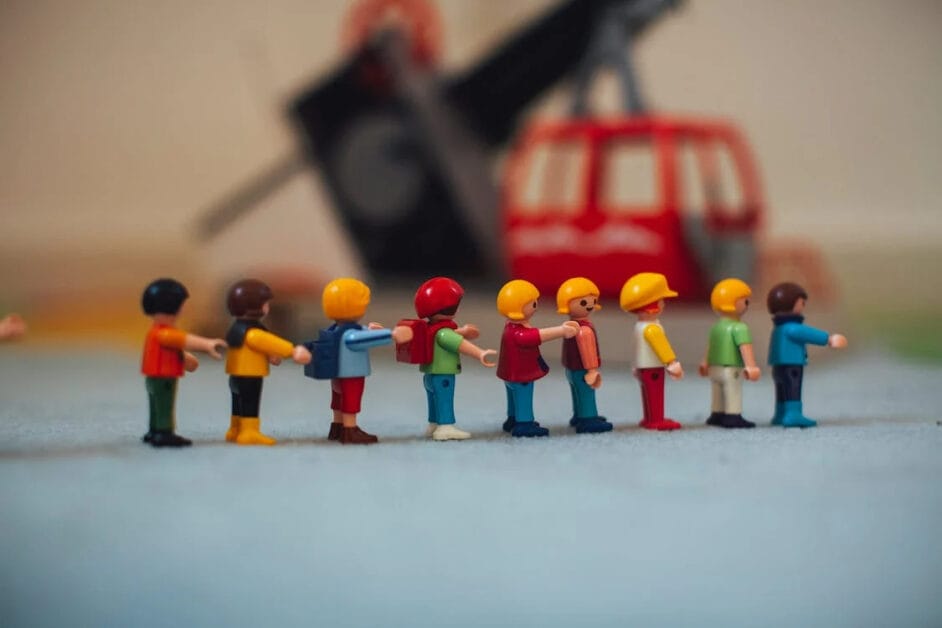 A group of toy people standing next to a toy crane