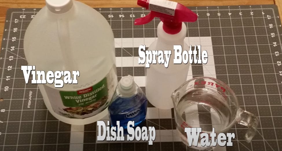 A homemade window cleaner consisting of vinegar and dish soap is prepared on a cutting board