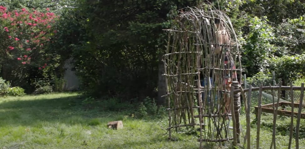 A woman building a garden arbor