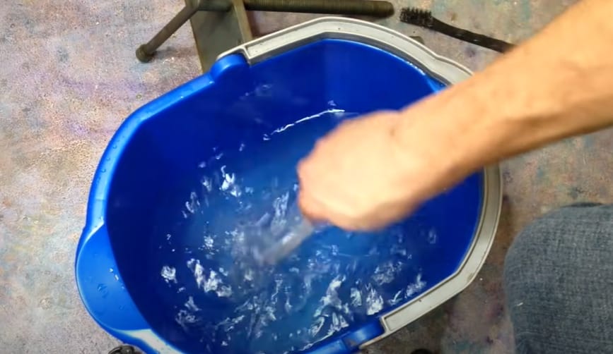 A person stirring the mixture of baking soda and water