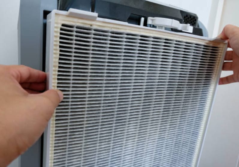 A person is removing the AC's filter
