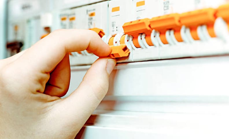 A person is checking the circuit breakers