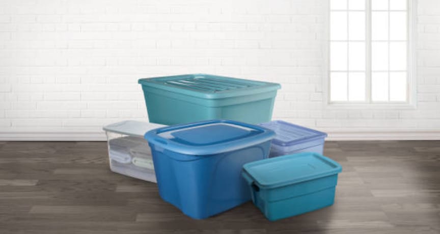 A stack of plastic storage containers on a wooden floor