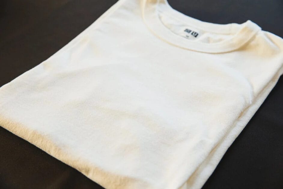 A folded white t-shirt on a black surface