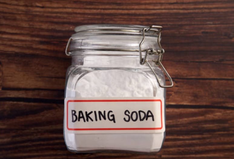 A jar of baking soda on a wooden table