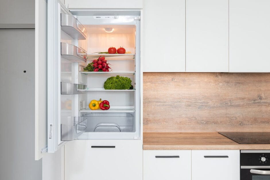 A white kitchen with an open refrigerator