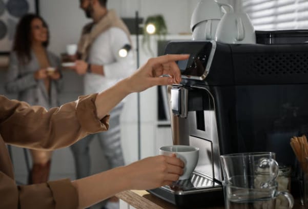 A woman is making her coffee in an espresso coffee maker