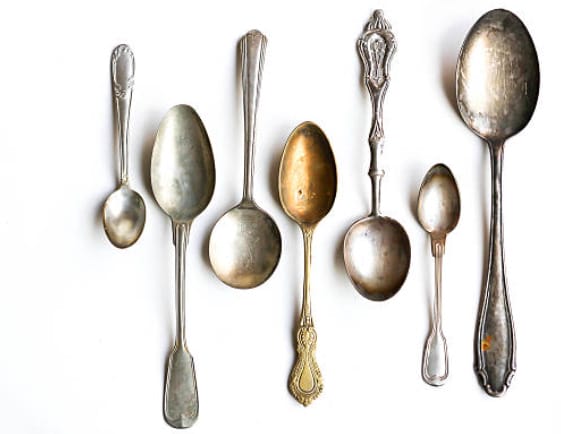 A shimmering collection of silver spoons on a pristine white background