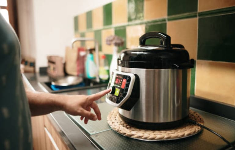 A person operating a pressure cooker in a kitchen