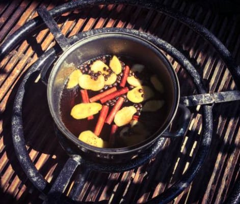 A pot of food simmering on top of a grill