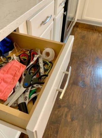 A drawer is filled with scissors and other items