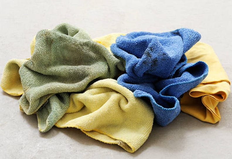 A stack of towels in a different color on a concrete floor