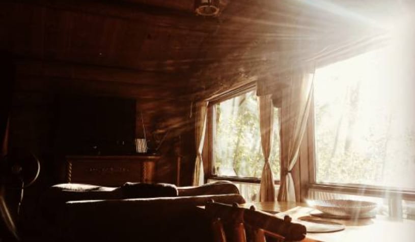 The sun is shining through a window in a cozy cabin