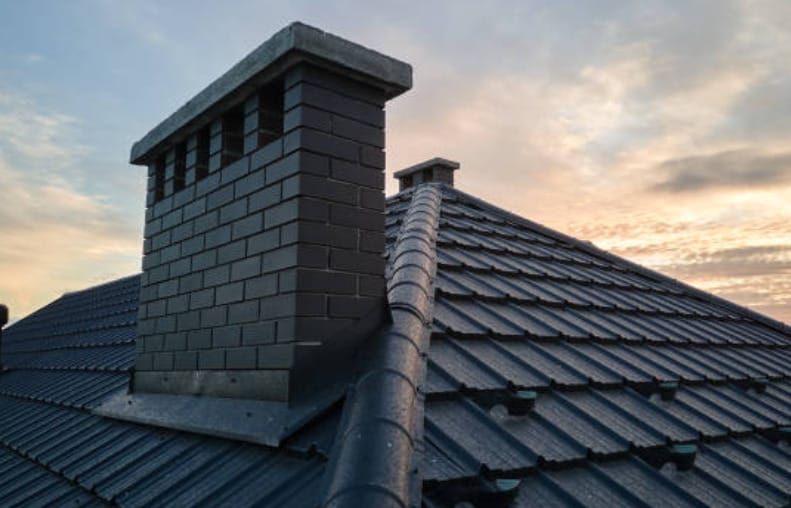 A close up image of a home's roof with chimney