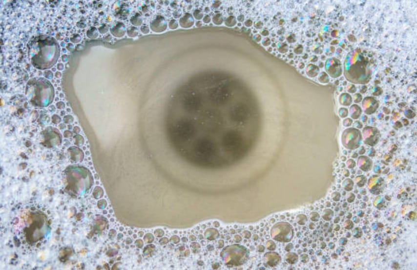 A close up of a soap bubble in clogging drainage sink