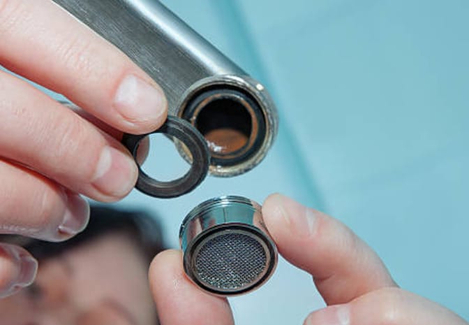 A person holding a faucet aerators