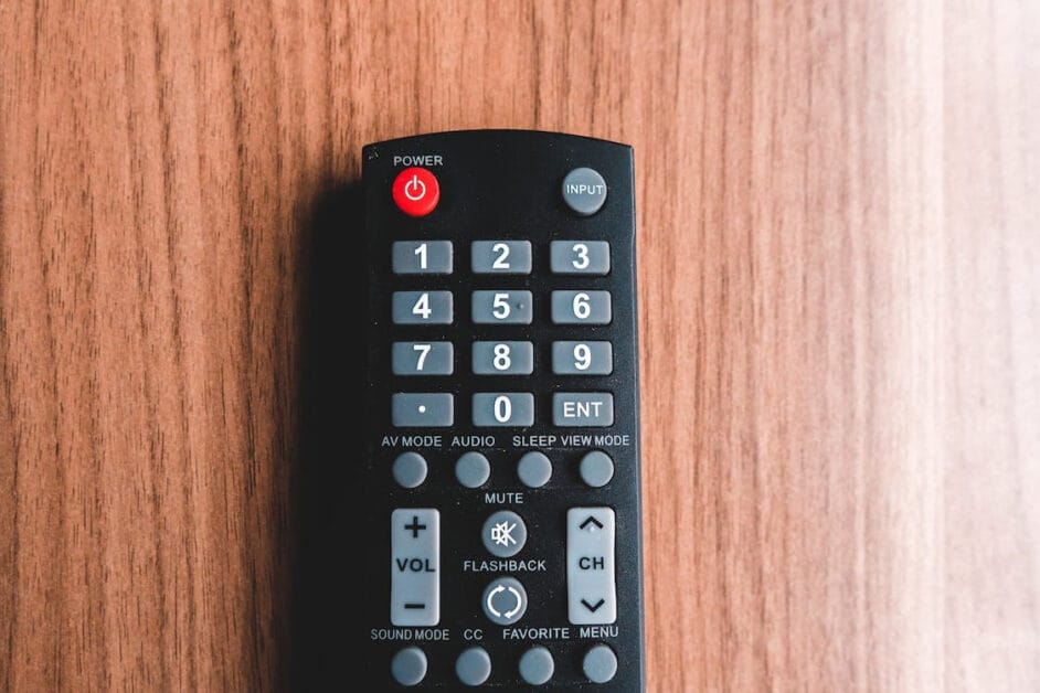 A remote control at a wooden table