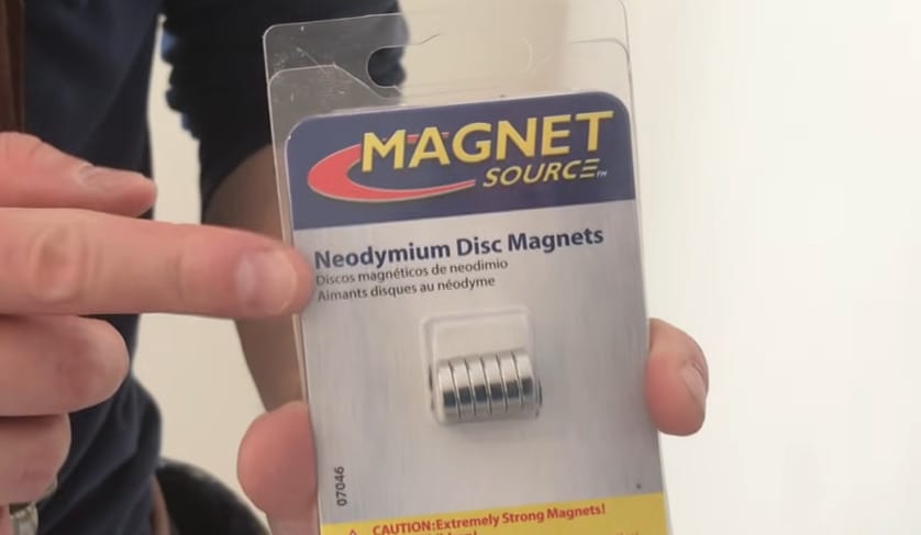 A person holding a pack of magnet