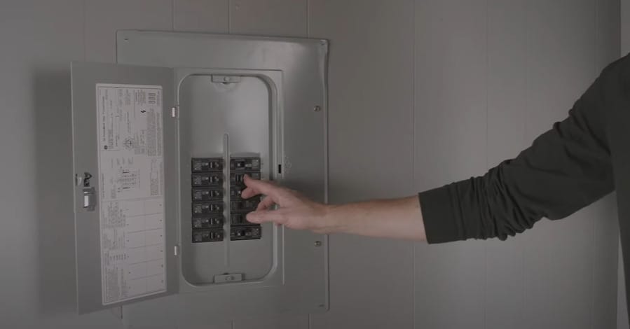 A person turning on the circuit breaker