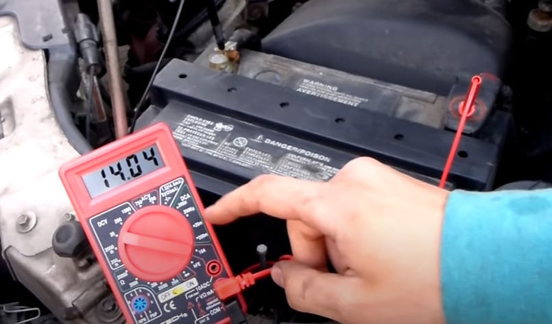 A person is using a multimeter to test car's battery
