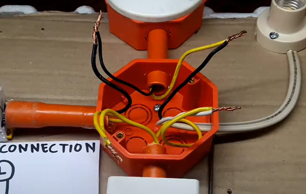 A wire connection in an orange electrical box