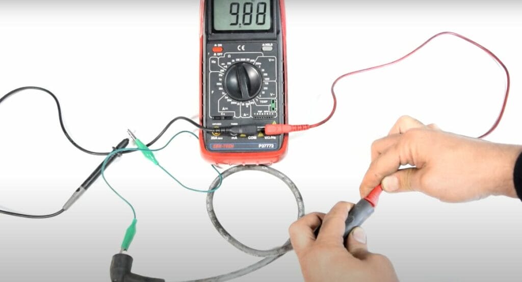 A person is testing a wire using a multimeter