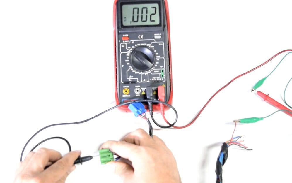 A person is using a multimeter to test wires