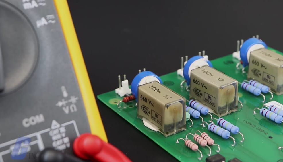 A circuit board with a multimeter used to read ohms