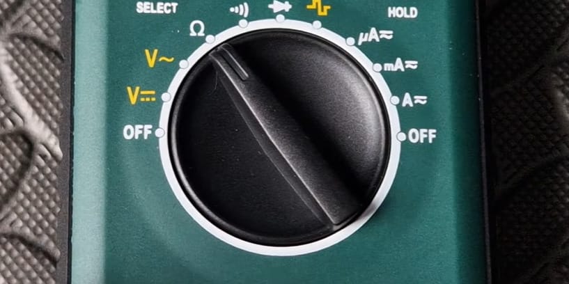 A green multimeter on a black surface