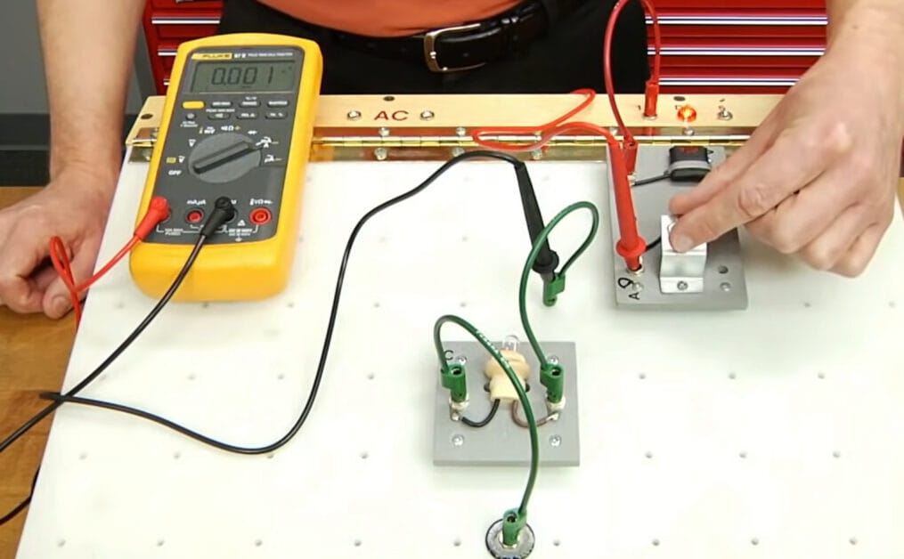 A person testing the circuit board with a multimeter