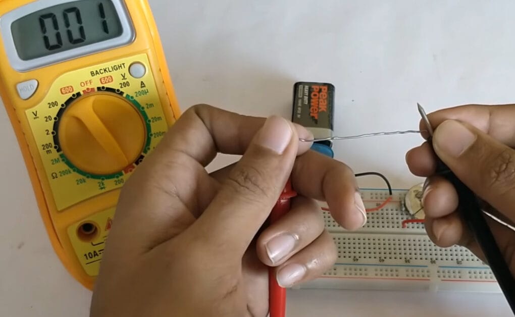 A person is using a conductor to test with multimeter