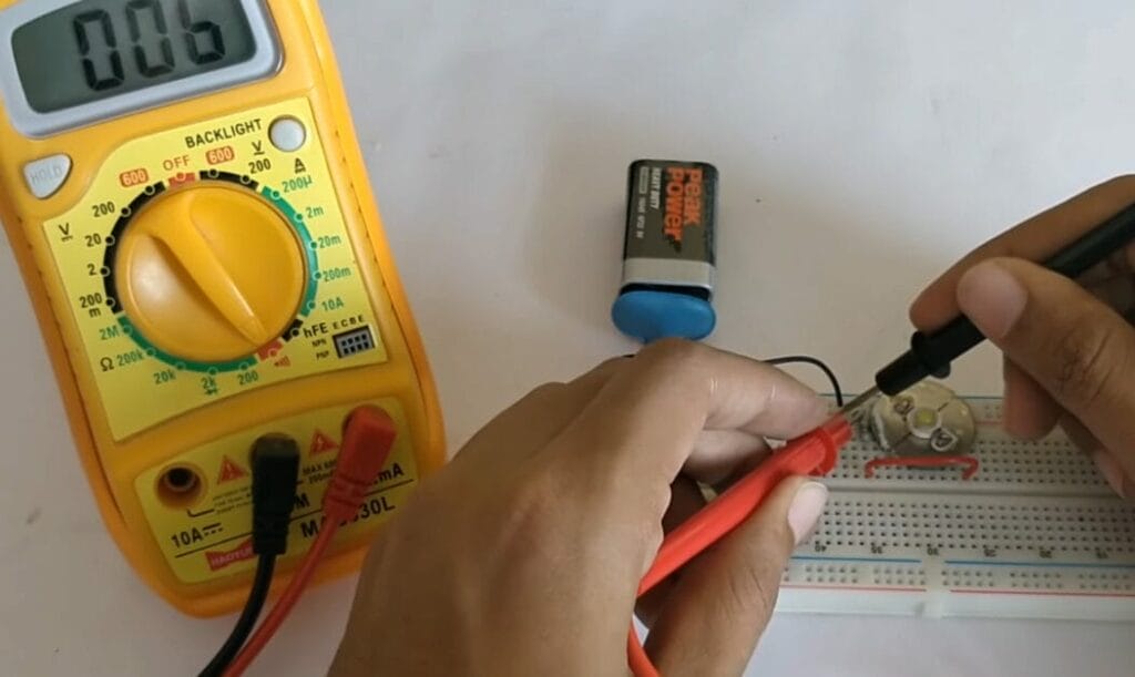 A person is using a multimeter to check continuity in a circuit board