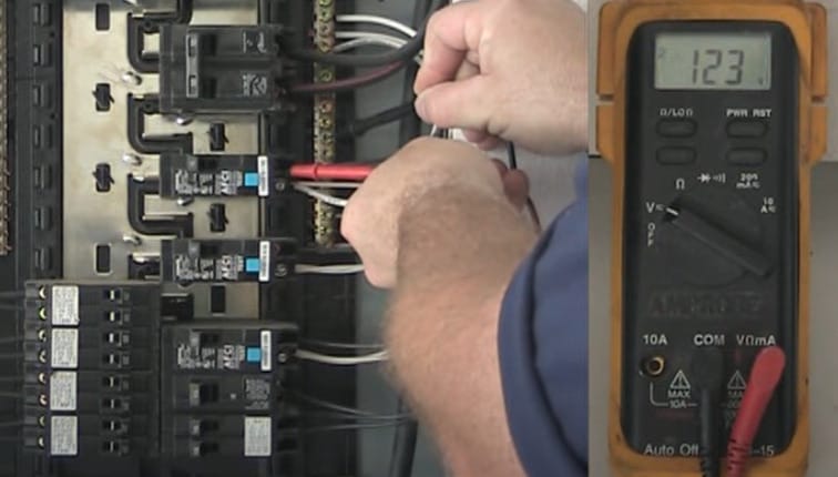 A man is testing a circuit breaker in a panel with a multimeter