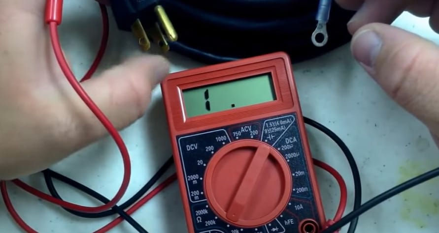 A person is using a cen tech multimeter to test wires