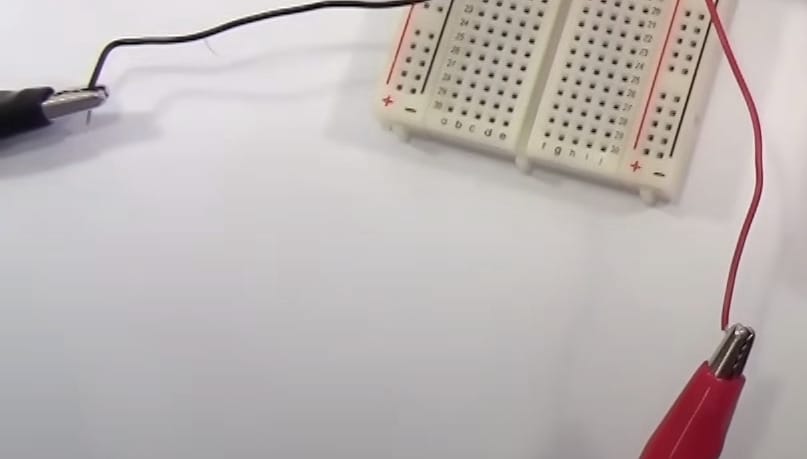 A breadboard with two wires connected to it for cen tech multimeter testing