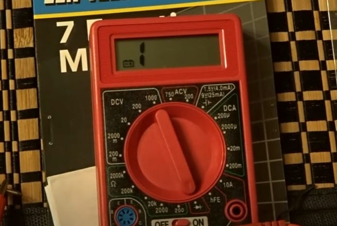 A Centech multimeter is sitting on a table next to a book