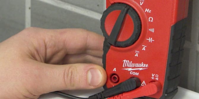 A person using a Milwaukee multimeter