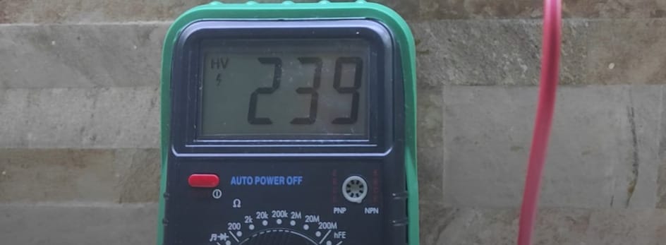 A digital multimeter is used to check an outlet.