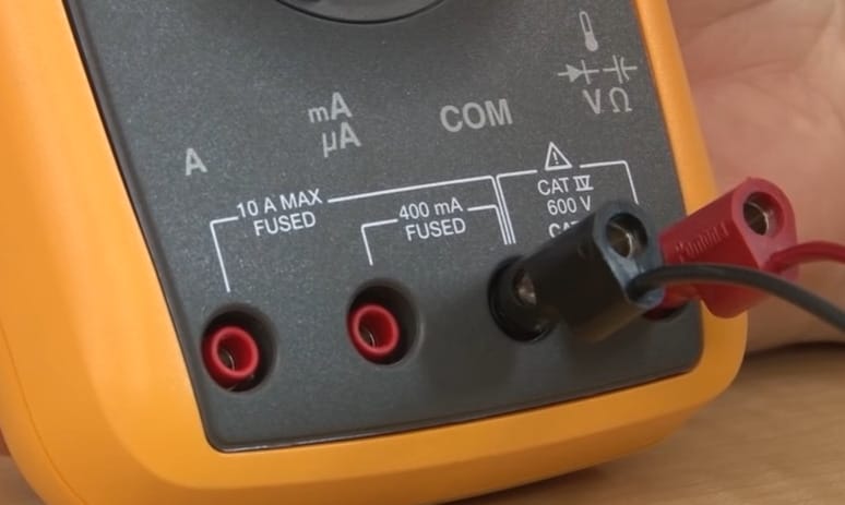 A person is holding a multimeter while observing the capacitance symbol