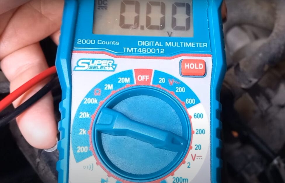 A person is setting the blue digital multimeter