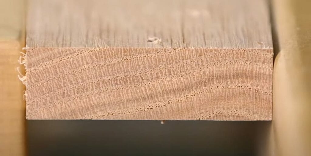 A close up of a piece of wood with screw holes and without a debris