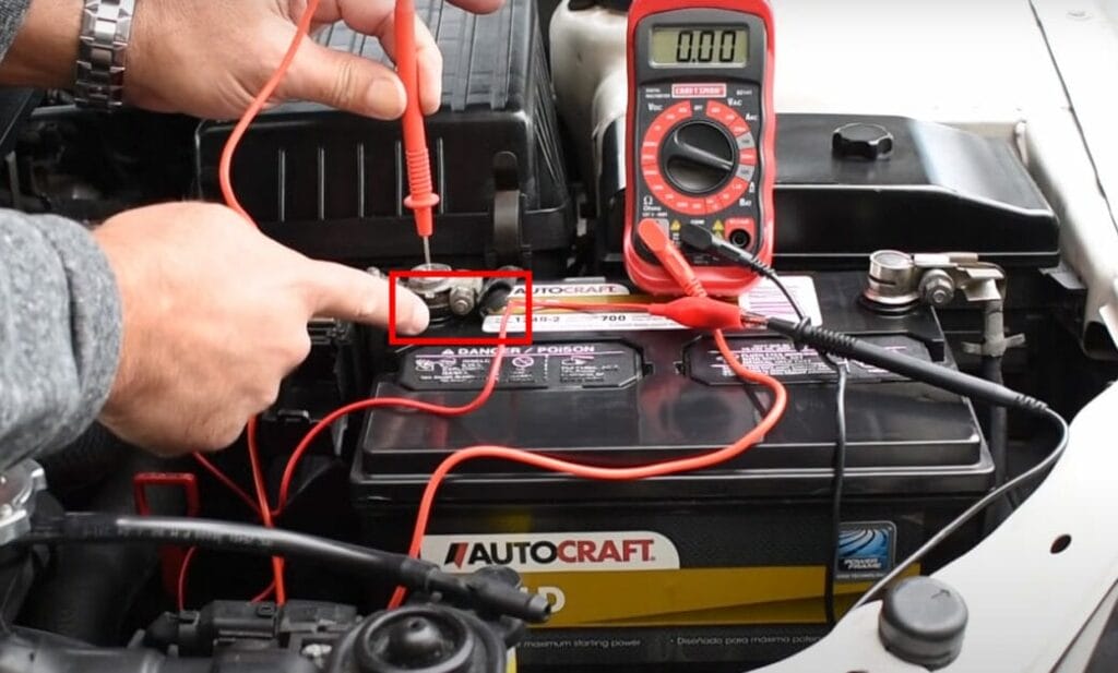 A person is testing the car's battery with a multimeter