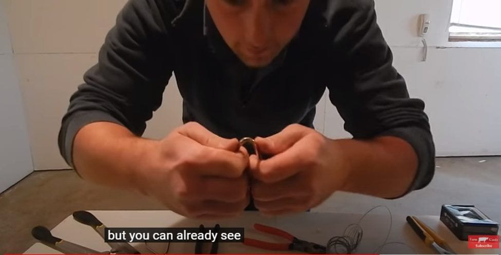 A man is working on a wire without wire cutters