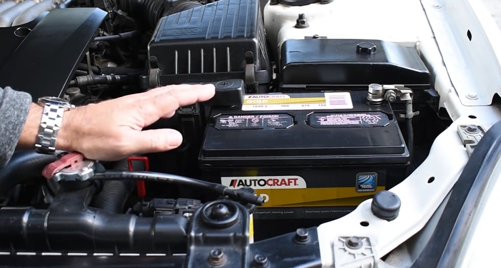 A person checking the battery in a car