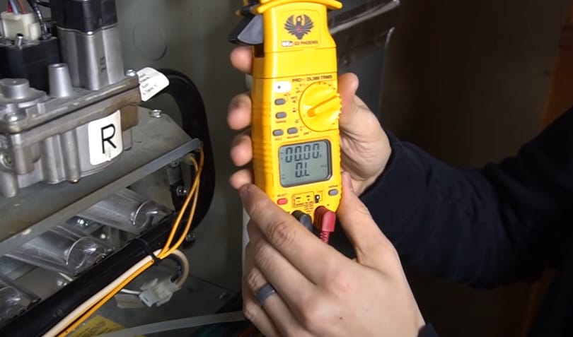 A person using a multimeter to test a circuit with a pressure switch
